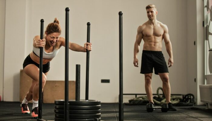 young-sportswoman-doing-sled-push